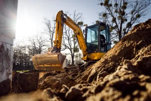 Contractor using rented mini excavator on a job site, saving time and costs with Sage Equipment Rentals
