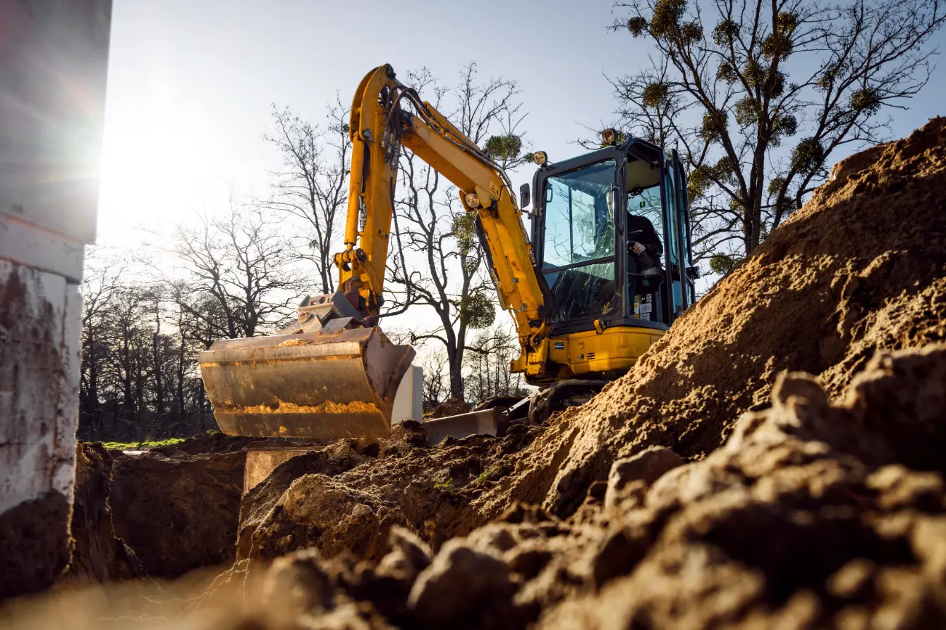Contractor using rented mini excavator on a job site, saving time and costs with Sage Equipment Rentals