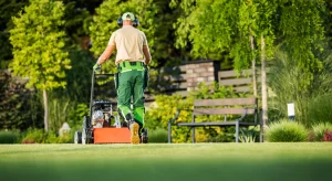 Homeowner using rented lawn aerator and hedge trimmer for weekend yard work from Sage Equipment Rentals