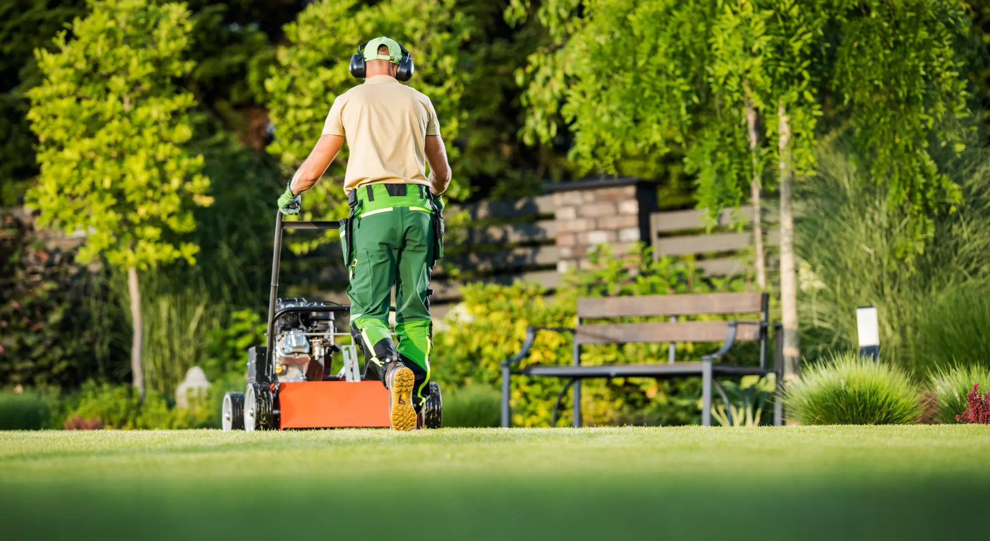 Homeowner using rented lawn aerator and hedge trimmer for weekend yard work from Sage Equipment Rentals